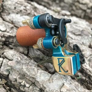 Handheld teal tattoo machine developed by Dan Kubin